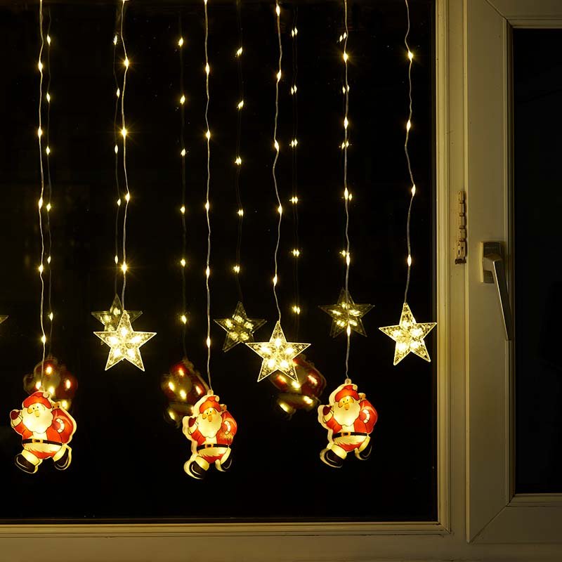 Smart Garden Warm White Xmas Star Santa Curtain Lights hanging illuminated in a window
