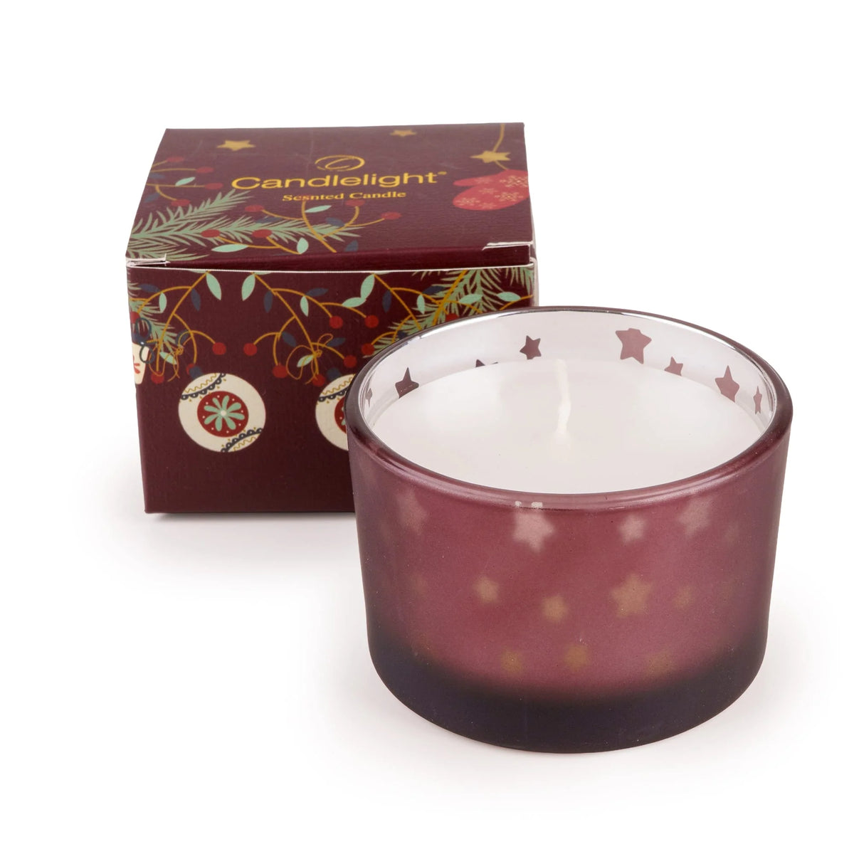 Candlelight red single scented candle in a star decorated glass vessel next to its festive stockings and baubles gift box