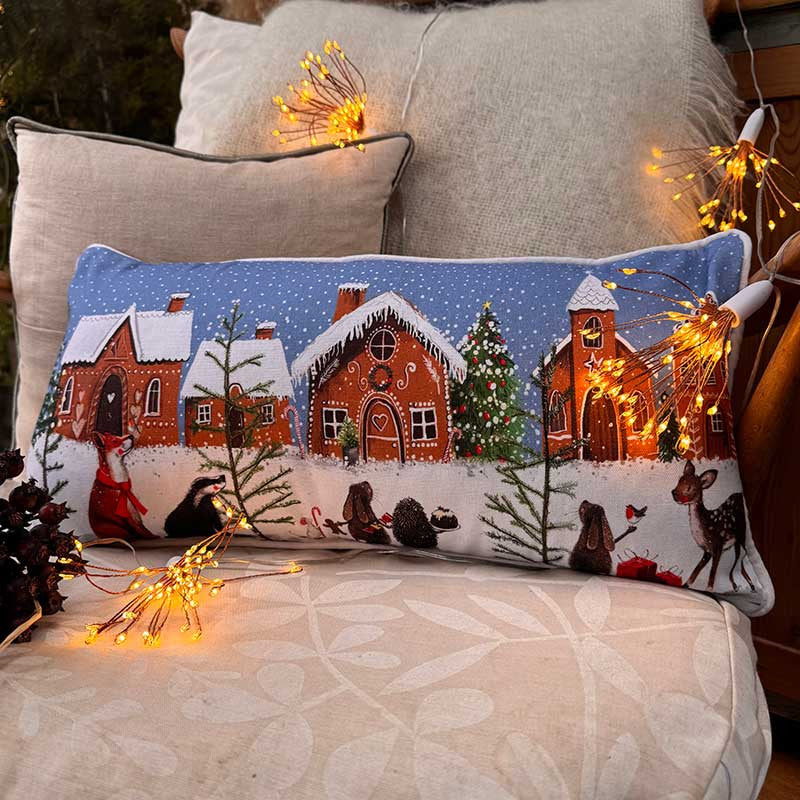 Alex Clark Gingerbread Village Christmas cushion featuring festive house and gingerbread illustrations