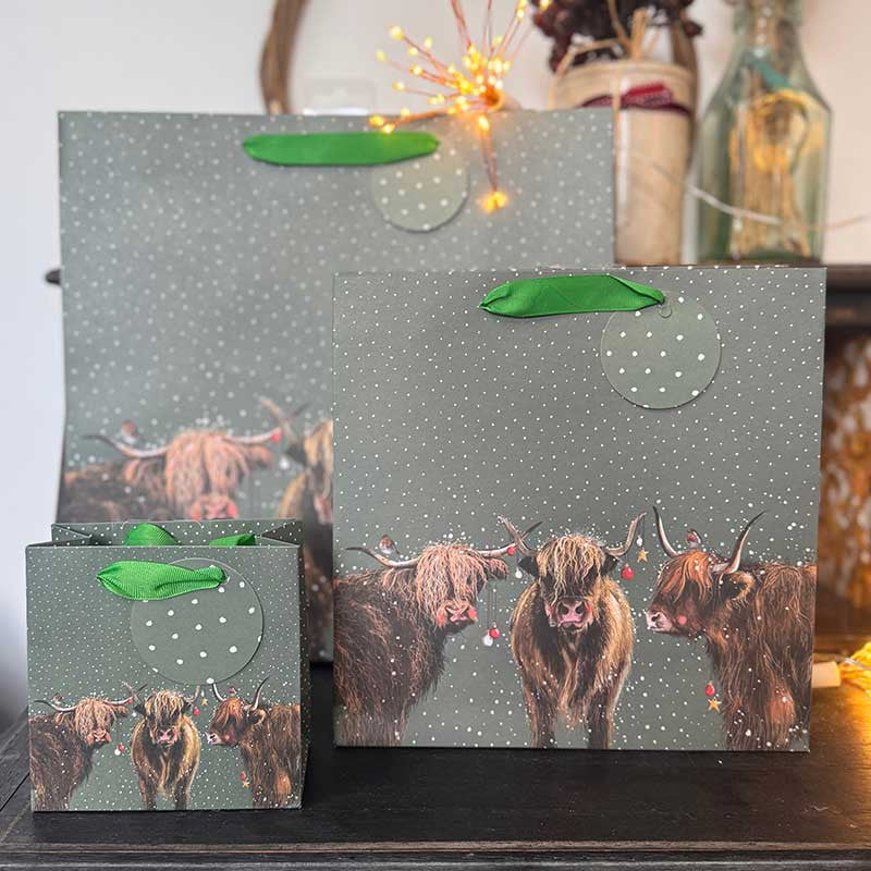 Alex Clark Highland Cows Christmas gift bag featuring festive countryside cattle artwork and ribbon handles