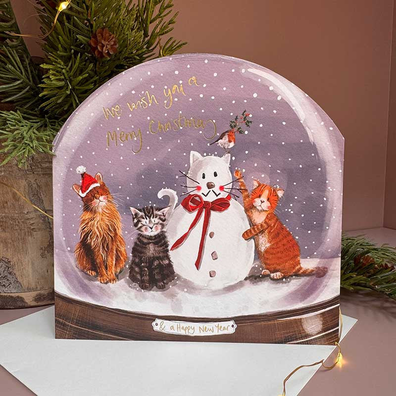 Alex Clark Cats & Snowman Snow Globe greeting card depicting curious cats around a snowman with a white envelope.