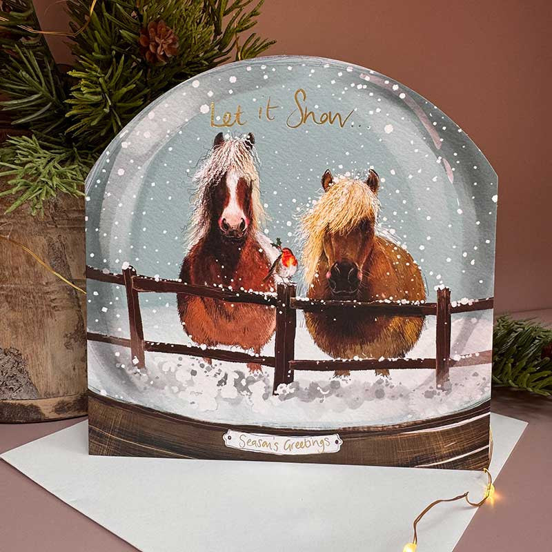Alex Clark Ponies Snow Globe greeting card depicting ponies in a snowy scene with a white envelope.