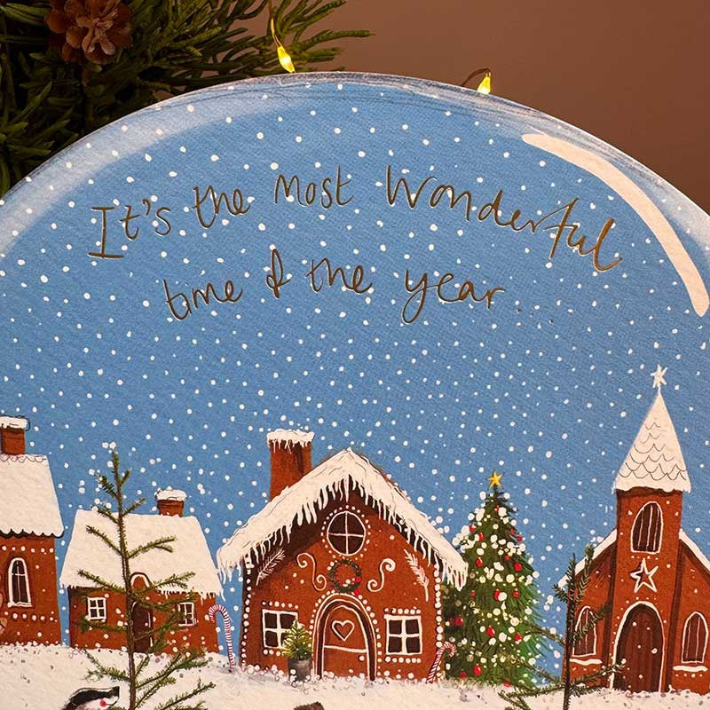 Alex Clark Gingerbread Village Snow Globe greeting card showing a sweet festive illustration with a white envelope.