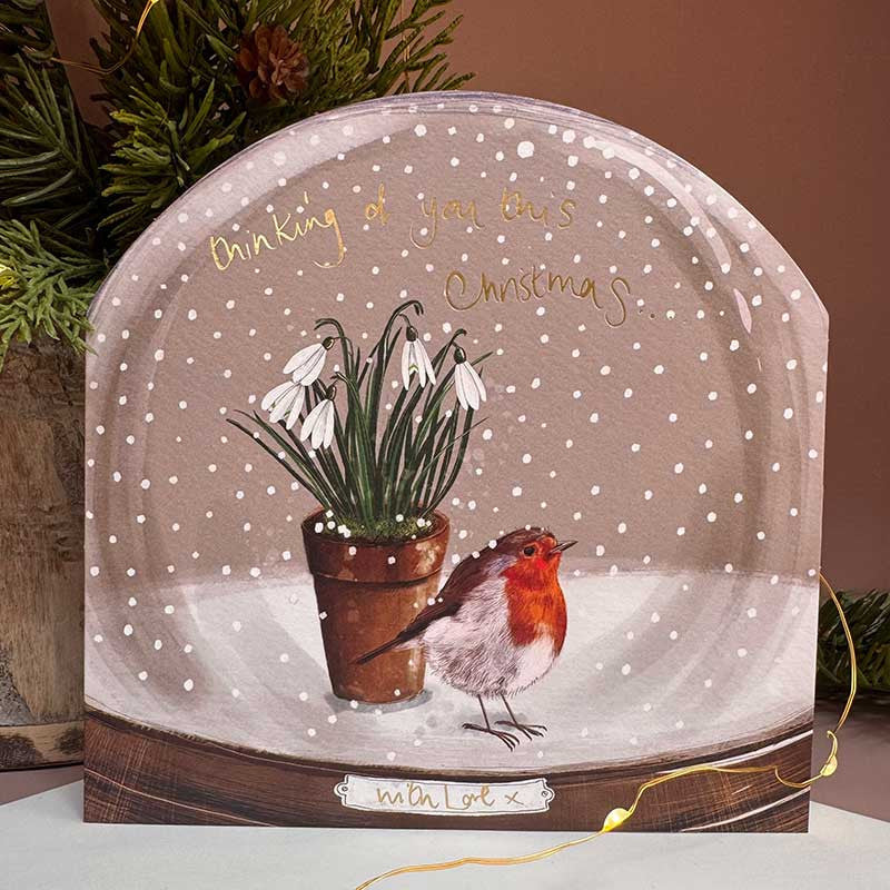 Alex Clark Thinking Of You Snow Globe greeting card with a whimsical winter illustration and white envelope.