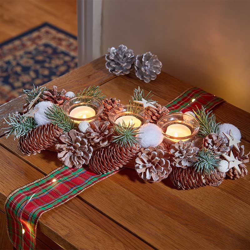 Smart Garden FrostPine Trio Candle Holder with frosted pinecones and three candle cups displayed on a dining table