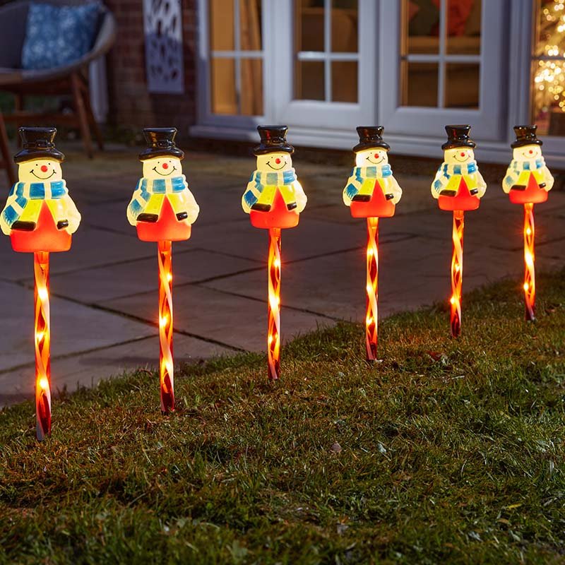Smart Garden Frosty Decor Stakes set of 6 lit up along a garden path in winter.