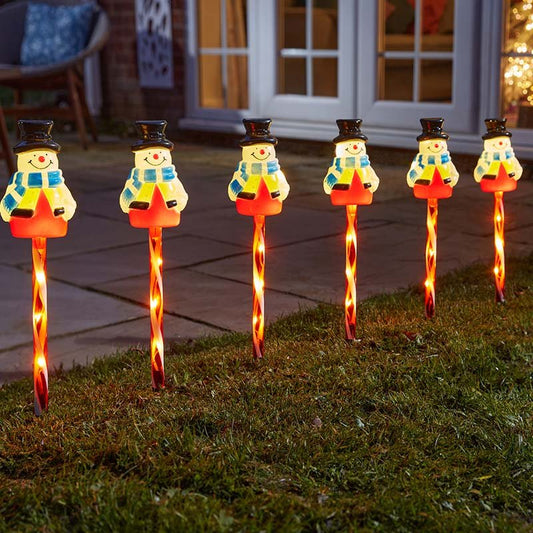 Smart Garden Frosty Decor Stakes set of 6 lit up along a garden path in winter.