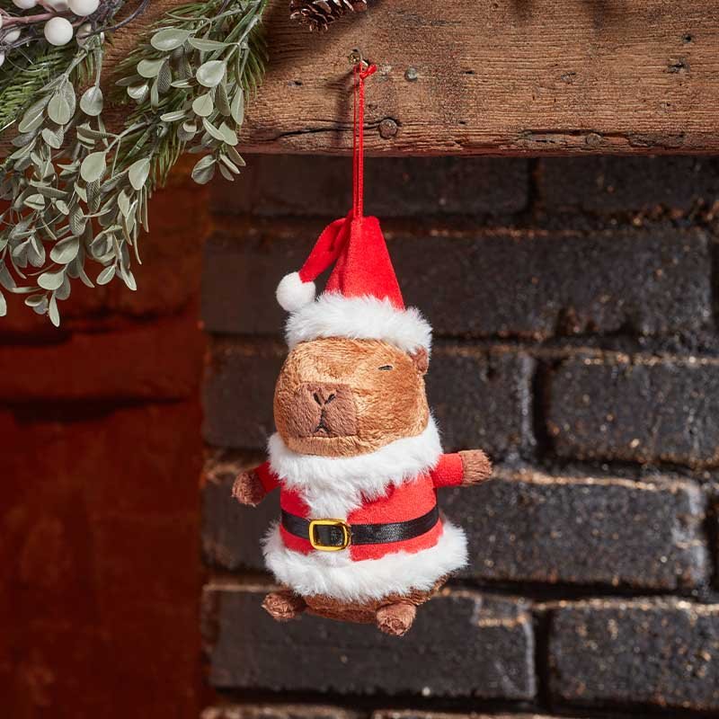 Smart Garden Santa Capybara plush hanging ornament hanging on a brick fireplace mantel