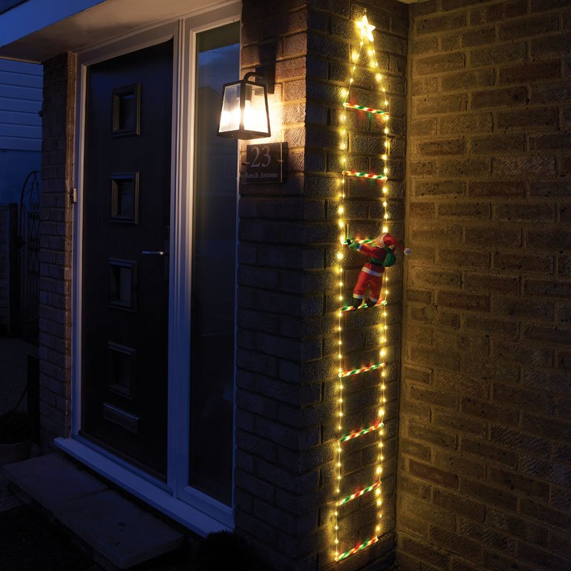 Smart Garden Santa's Ladder illuminated with warm white LEDs against an exterior house wall at night.