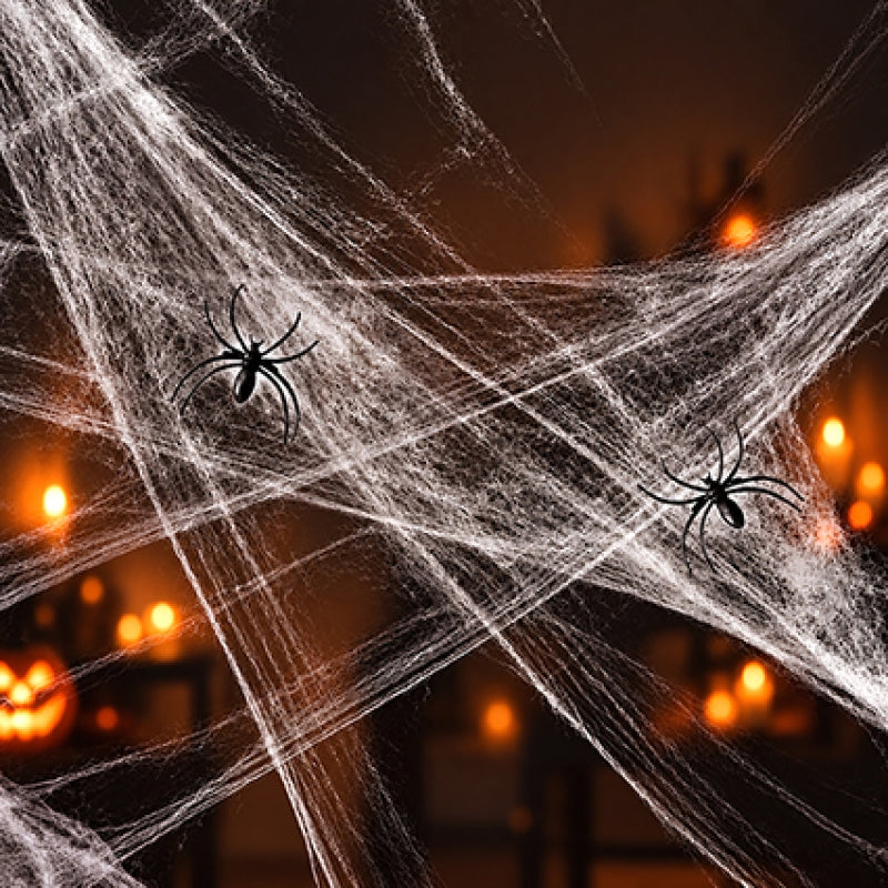 Premier white stretchable cotton style cobweb Halloween decoration draped over a surface with two black plastic spiders attached.