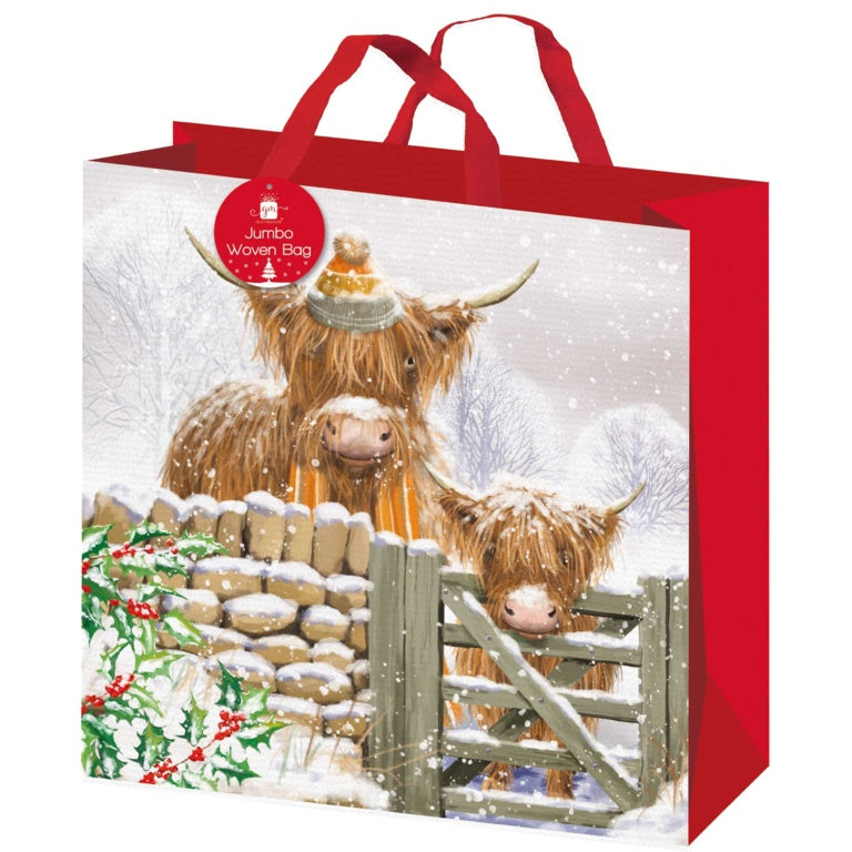 Design Group Giftmaker jumbo PP woven Christmas gift bag featuring Highland cows in a snowy winter landscape.
