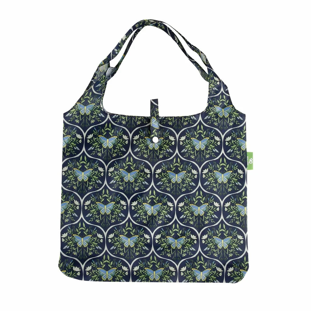 Eco Chic lightweight foldable reusable shopping bag featuring blue butterflies and botanical trellis pattern on navy fabric
