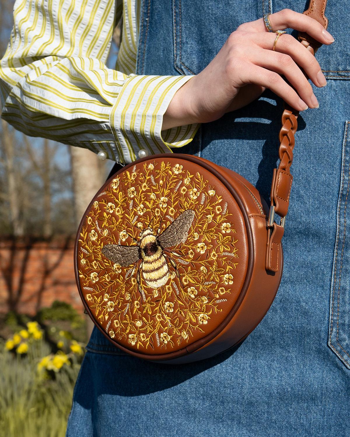 Fable Bumble Circle Bag in tan faux leather featuring detailed embroidered bee and floral pattern
