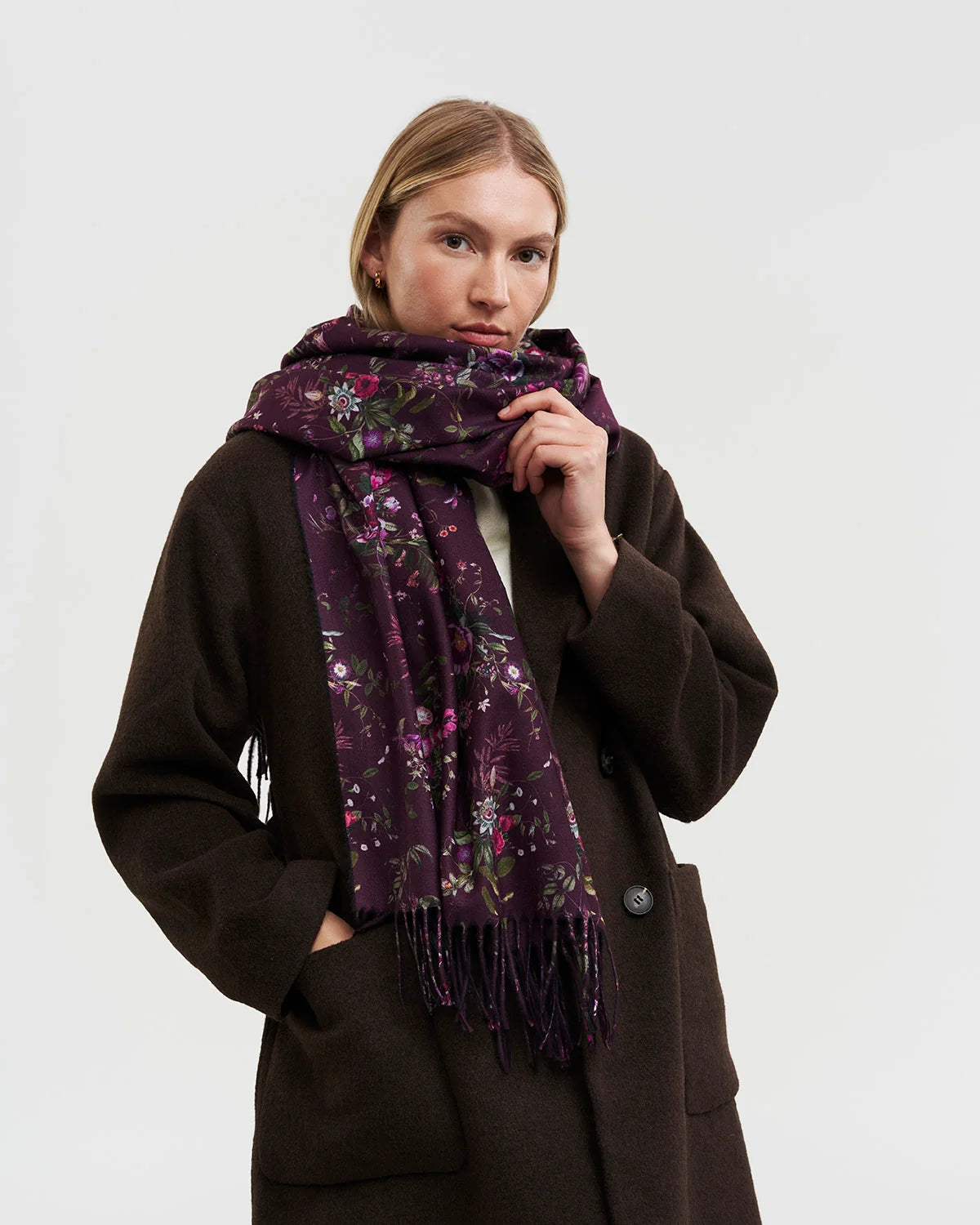 Fable Eve Floral Fringed Scarf in Burgundy wrapped around model's neck featuring floral print and long fringe detail