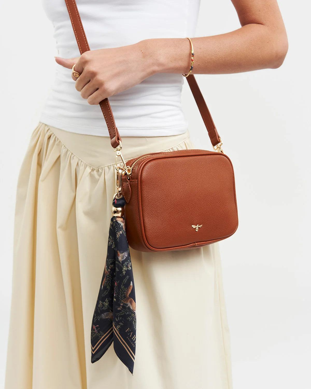 Fable Into the Woods Scarf Bag Charm attached to a brown leather handbag showing gold clip and printed scarf