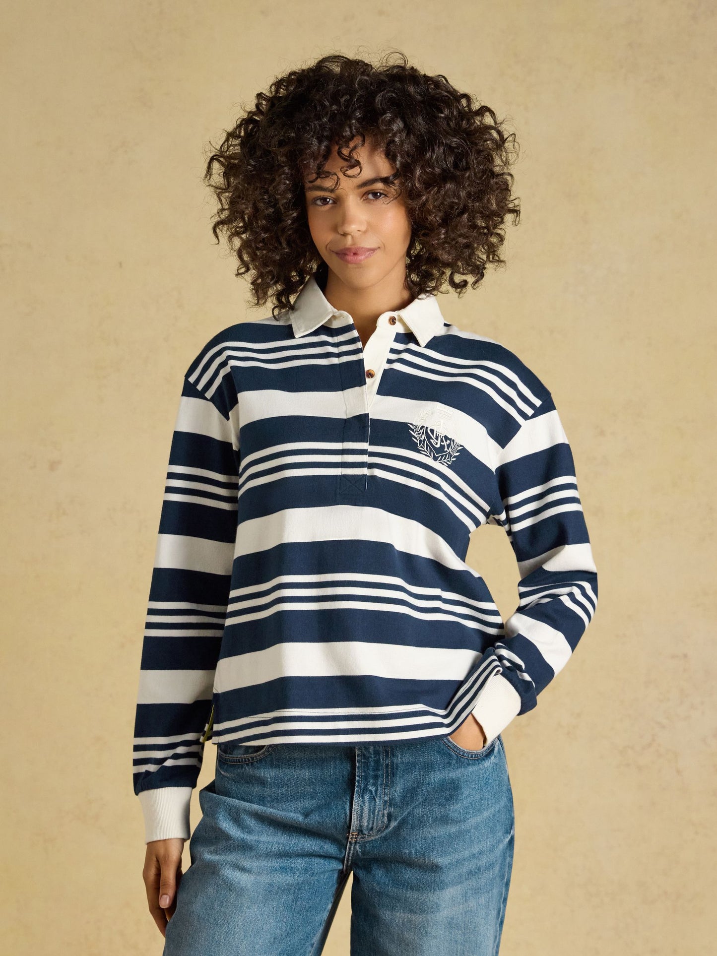 Woman wearing the Joules Lara Cotton Collared Long Sleeve Rugby Shirt in a preppy casual design