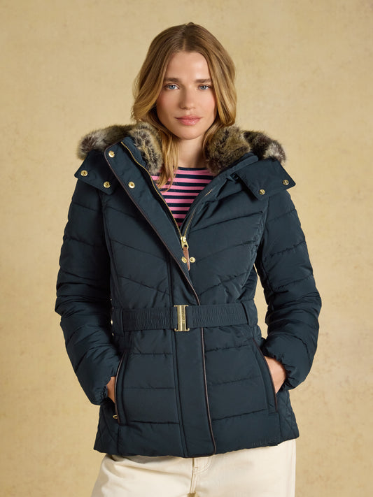 Joules Aspen women's showerproof padded coat in mid-thigh length with a belted waist and faux fur hood trim.