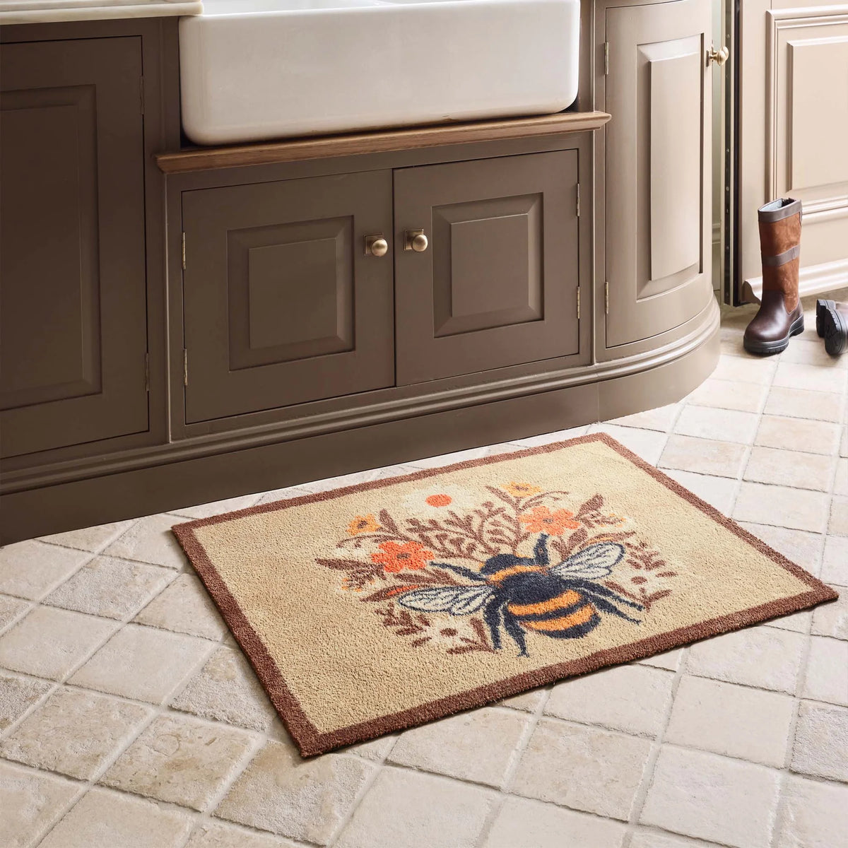 Hug Rug Floral Bee Beige washable doormat with central bee illustration laid in a kitchen interior