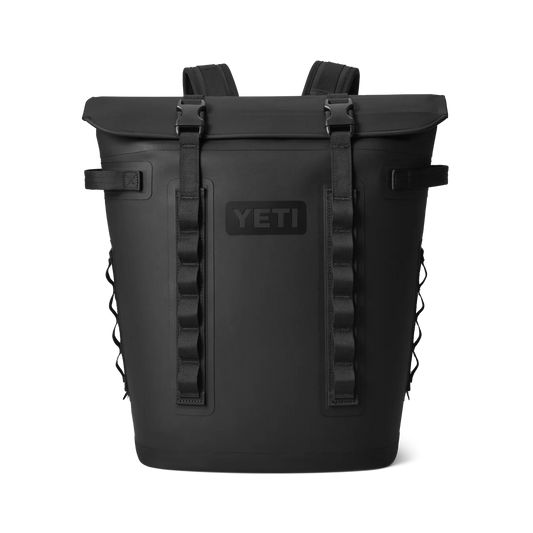 YETI Hopper M20 Soft Cooler Backpack in use outdoors, showing the ergonomic shoulder straps and durable black exterior.
