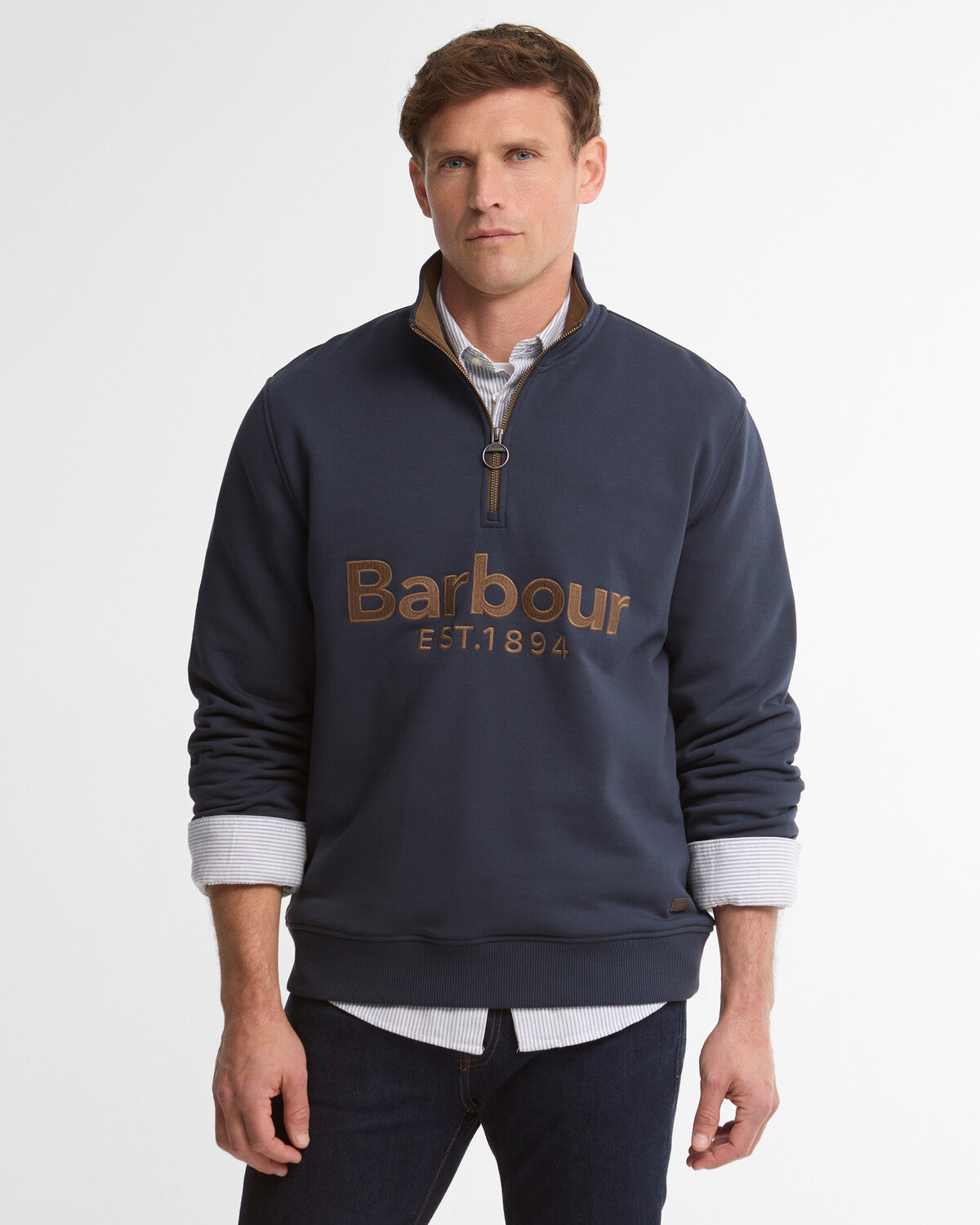 Man wearing a navy blue Barbour Fosse half-zip sweatshirt with a high neck, ribbed cuffs, and a cream-coloured heritage chest logo.