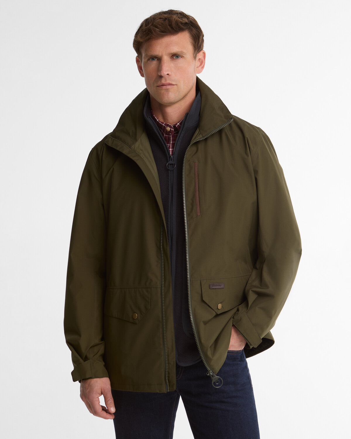 Man wearing an olive green Barbour Uldale men's regular-fit waterproof jacket with a full-zip front and leather neck badge.