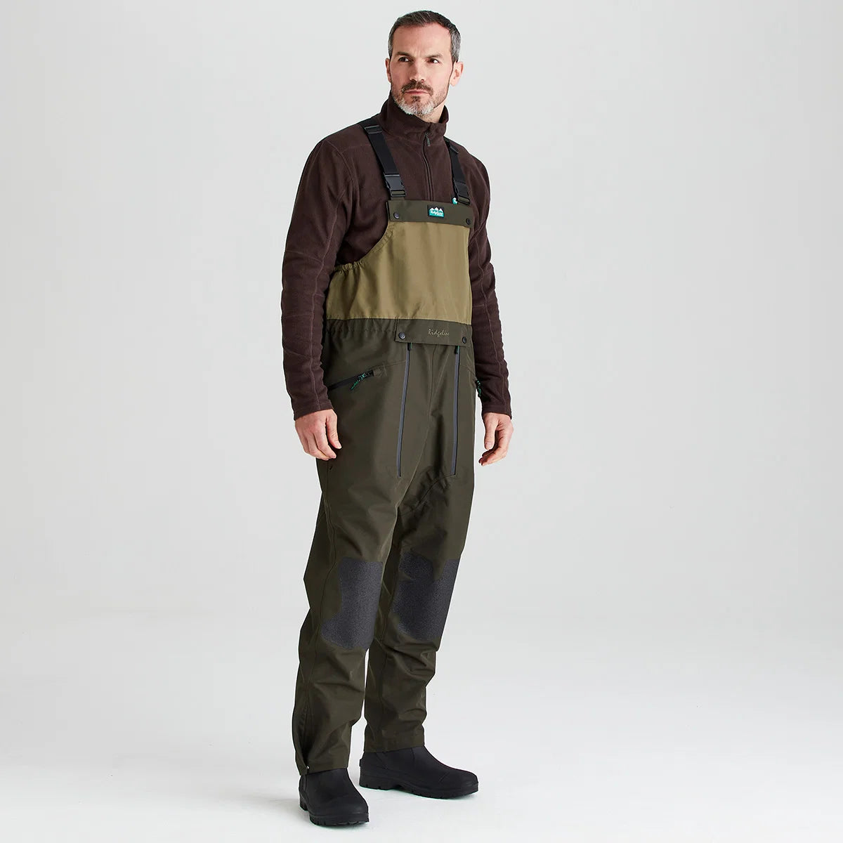 Ridgeline Men's Agri Pro Bib and Brace in action with adjustable braces and reinforced knee patches.