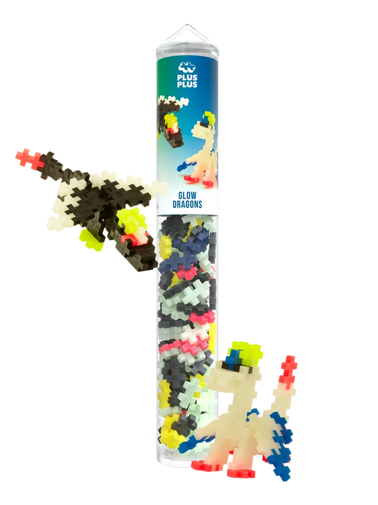 Plus-Plus Glow Dragons clear tube container displayed with built black and white glow-in-the-dark toy dragon figures.