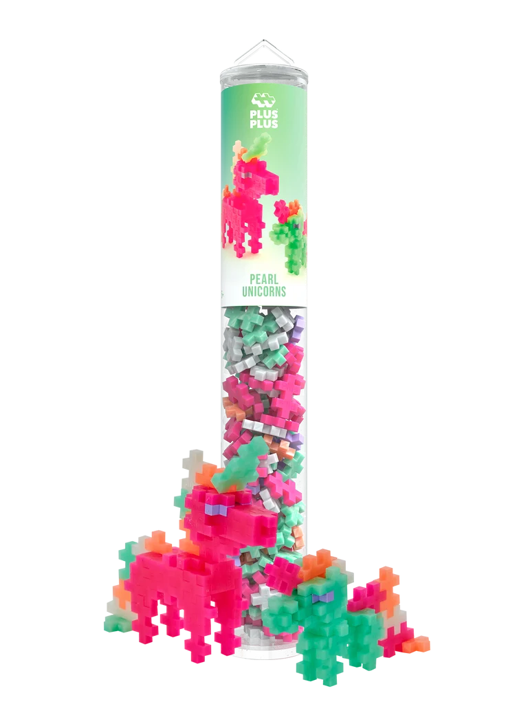 Plus-Plus Pearl Unicorns clear storage tube standing next to constructed pink and green toy unicorn figures.