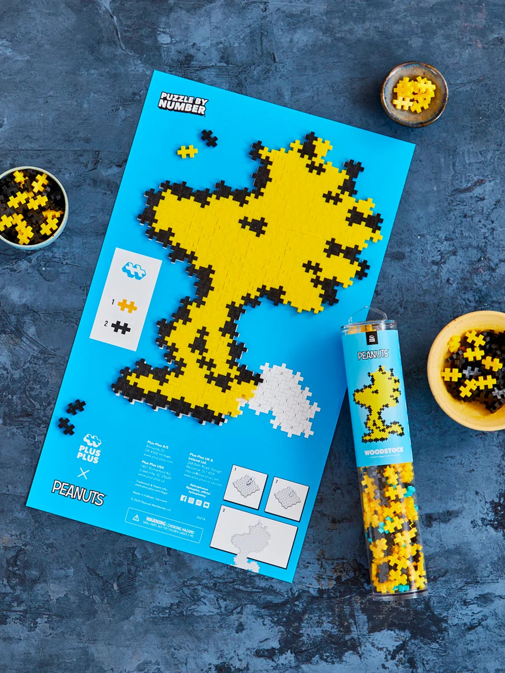 Plus-Plus Woodstock storage tube alongside a completed pixelated yellow Woodstock character build.