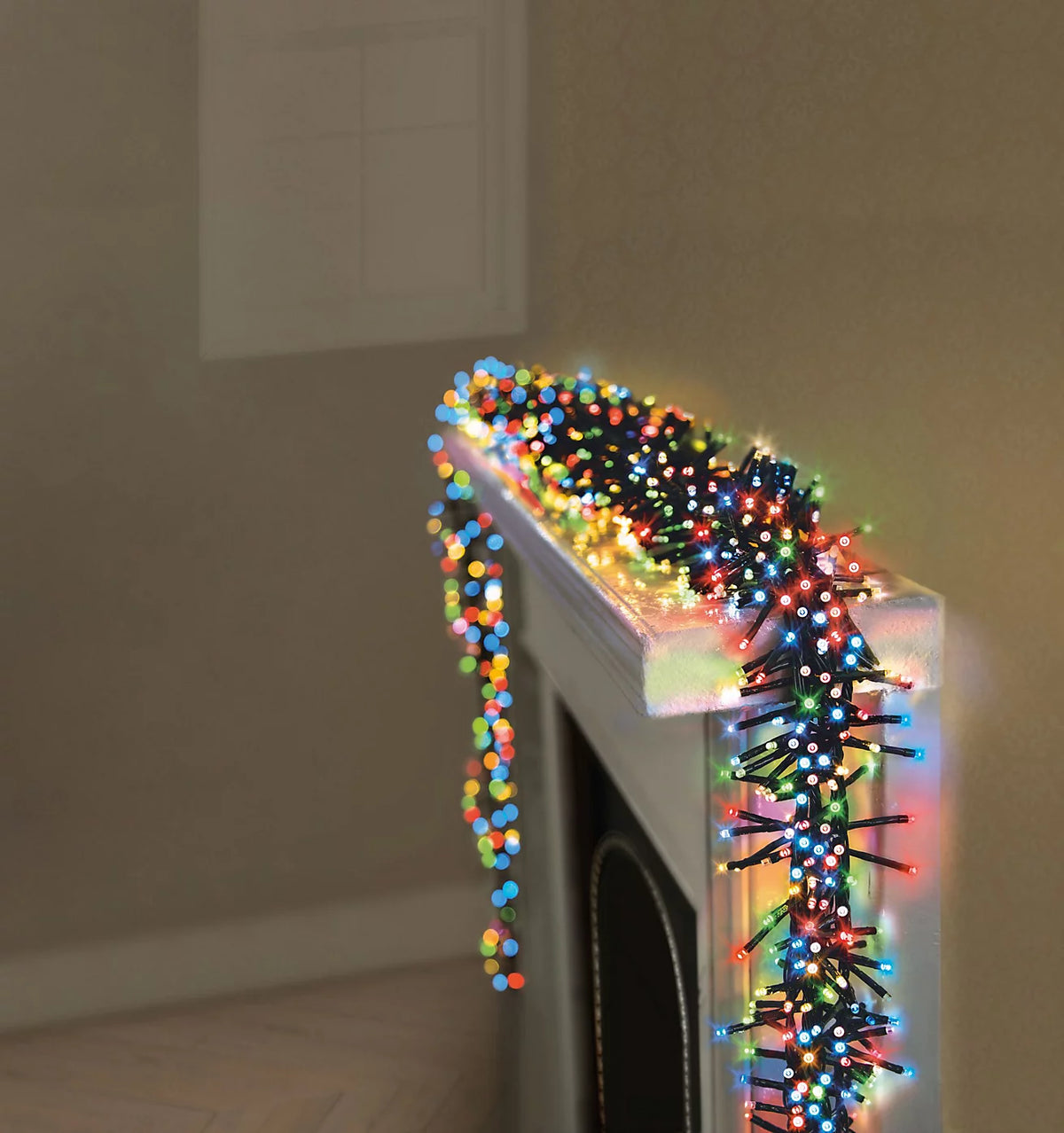 Premier 720 multi-coloured LED Christmas cluster lights decorated around an outdoor house roofline and fireplace mantel.
