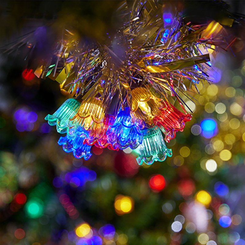 Premier 80 LED multi-action retro bell Christmas lights with colourful bell caps glowing on a Christmas tree