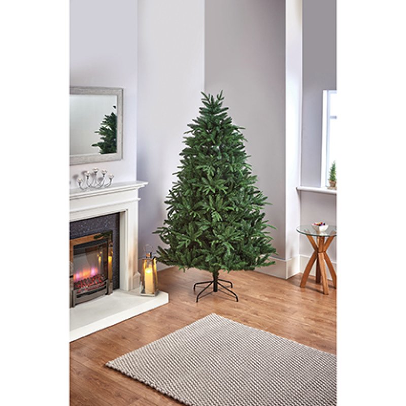 Premier 1.8m Aspen Fir hinged artificial Christmas tree standing on a metal base in a living room setting.