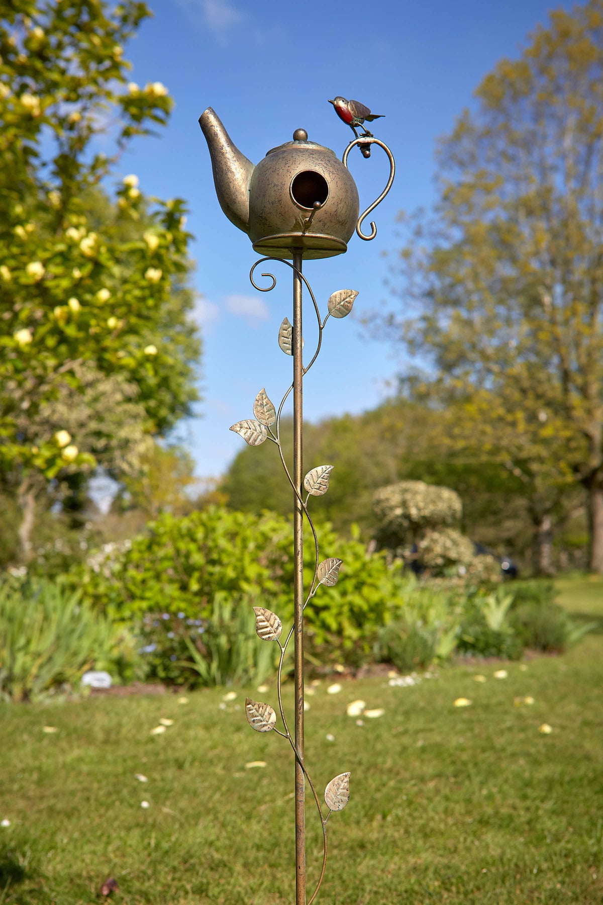 Tom Chambers Robin Teapot Nester plant stake with decorative robin figure against a garden backdrop.