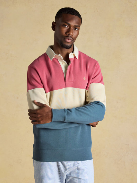 Men wearing a navy and red colour-blocked Joules French rib long sleeve rugby shirt with a white twill collar.