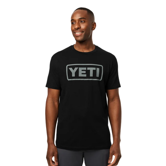 Men wearing YETI Full Logo Badge Short Sleeve T-Shirt in grey and black featuring front printed YETI badge logo
