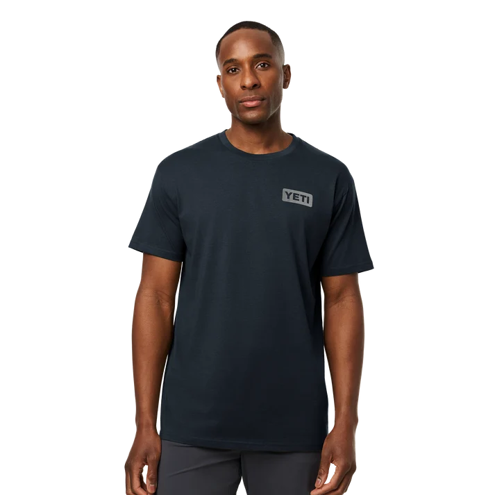Front and back view of man wearing dark navy YETI short sleeve t-shirt with subtle left chest logo badge