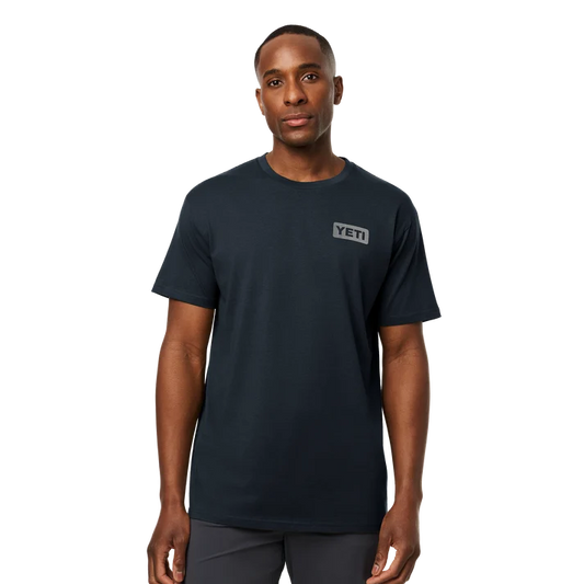 Front and back view of man wearing dark navy YETI short sleeve t-shirt with subtle left chest logo badge