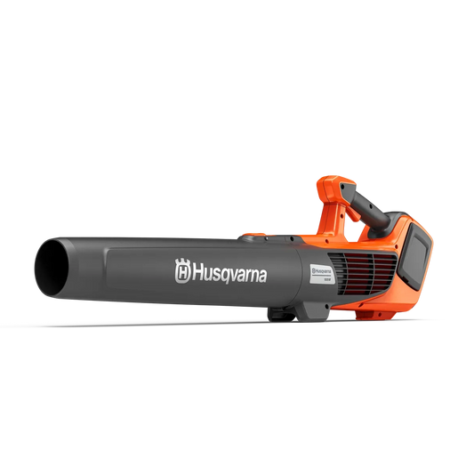 Husqvarna 122iB cordless 36V handheld leaf blower clearing leaves and garden debris from a gravel pathway
