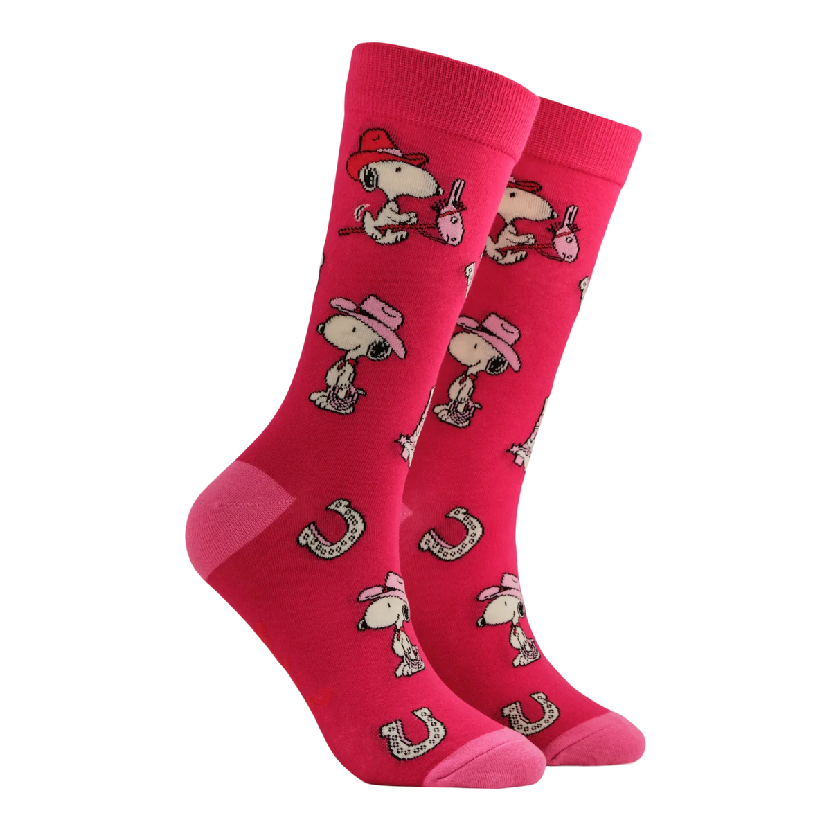 Socktopus In the Saddle Peanuts socks featuring Snoopy wearing a cowboy hat with horseshoes on a bold pink background